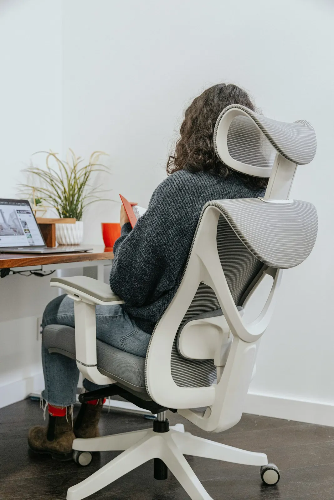 Posto de trabalho com cadeira ergonômica ajustada, apoio lombar e encosto de cabeça